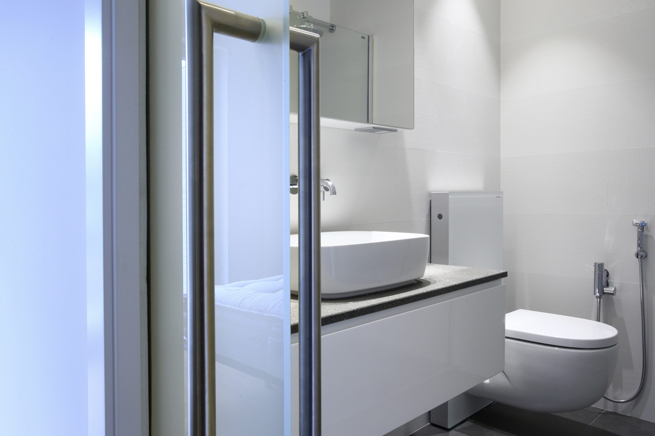 Cuarto de baño reformado con lavabo sobre encimera y trasdosado de pladur