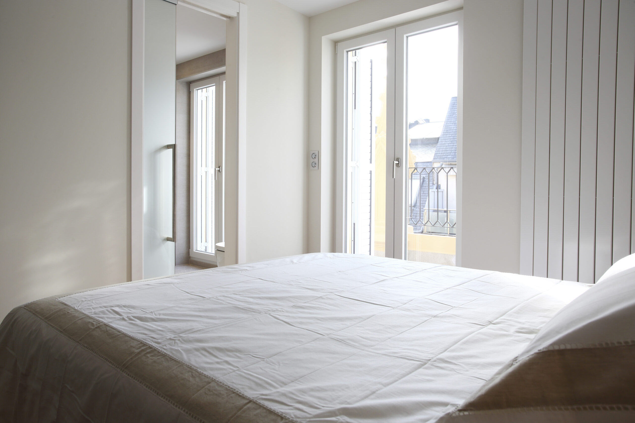 Dormitorio luminoso con puertas a la terraza, reforma interior